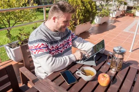 Happy man having breakfast with technology in the garden Stock Photos
