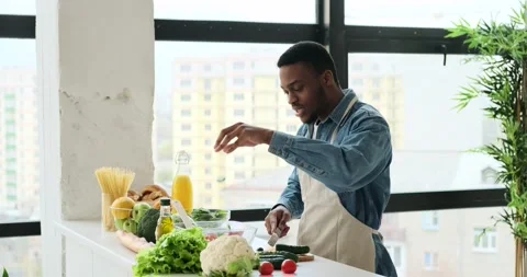Happy man having fun while preparing food in kitchen 動画素材 153686169