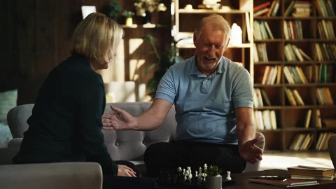 Happy man in his 70s playing chess with adult daughter, enjoying board game Stock Footage 331162388