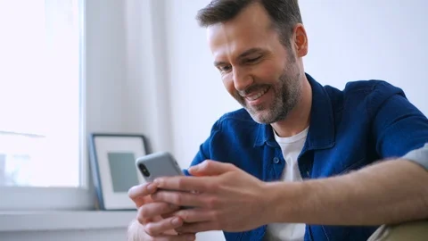 Happy man at home using smartphone Stock Footage 127124107