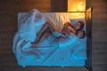 The happy man hug a woman on the bed. evening night time. view from above Photo