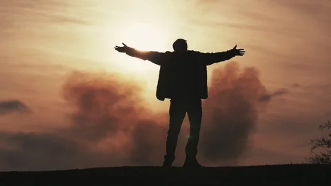 Happy man keeping hands aside and turning around at a cloudy sunset in slo-mo Stock-Footage 105246394