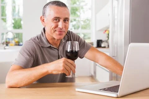 Happy man at kitchen table Foto stock