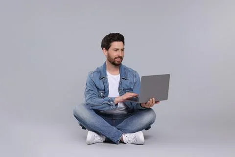 Happy man with laptop on light grey background Stock Photos