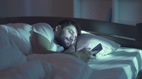 The happy man lay on the bed and phone. Evening night time. Real time capture Stock Footage 71965095