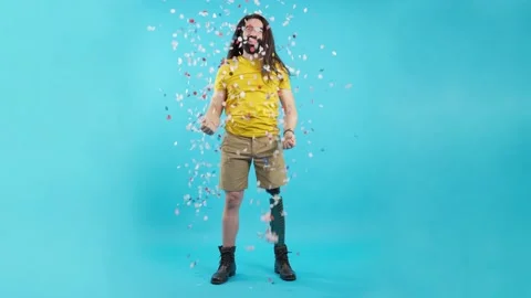 Happy man with a leg prosthesis surrounded by flying confetti 動画素材 228010319