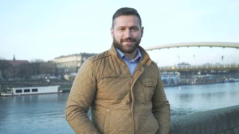 Happy man looking to camera on the background of the river, steadicam Vídeo Stock 72775728