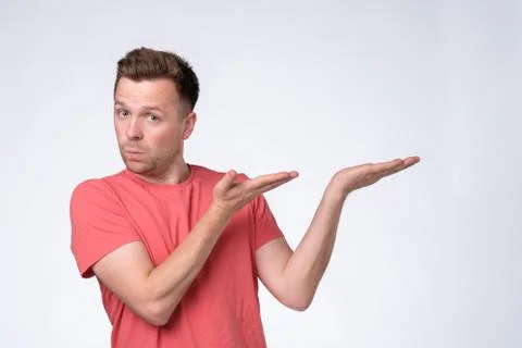 Happy man looking at camera, smiling and pointing aside with hand. Stock Photos