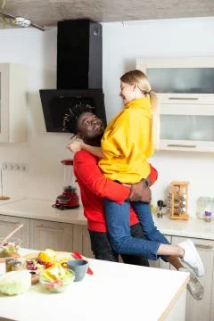 Happy man looking at the girlfriend while holding her in his arms Stock Photos