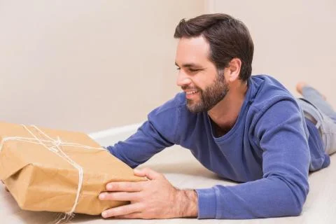 Happy man looking at package Photos