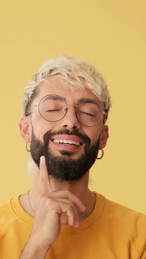 Happy man looking up to show mockup space isolated on yellow background in Stockbeeldmateriaal 253935599