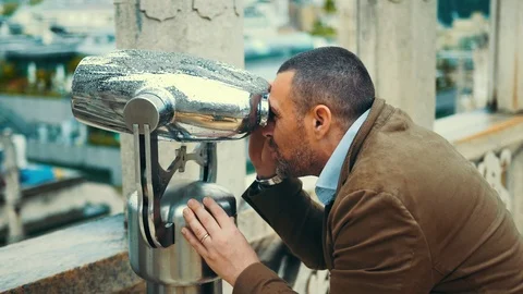 Happy man looking through a viewing scope Stock Footage 108601210