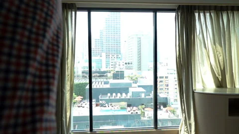 Happy man looking from the window in his apartment and feels like a winner, slow Stock Footage 88280922
