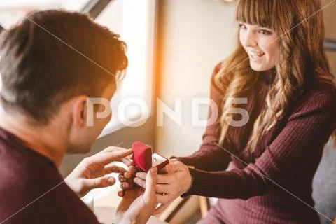 The happy man makes an offer to his girlfriend in the restaurant Stock Photos