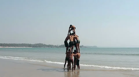 Happy man making human pyramid on the Palolem beach Stock Footage 66470953