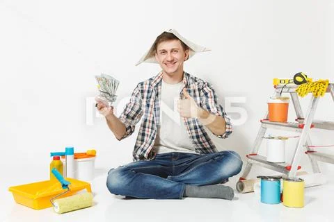Happy man in newspaper hat holds bundle of dollars, cash money. Instruments f Stock-Fotos