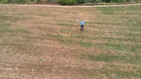 Happy man with open arms in field concept of freedom drone shot Stock Footage 116384337