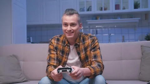 Happy Man Playing Video Console at Gamepad Joystick Controller and Winning Game Stock Footage 241558965