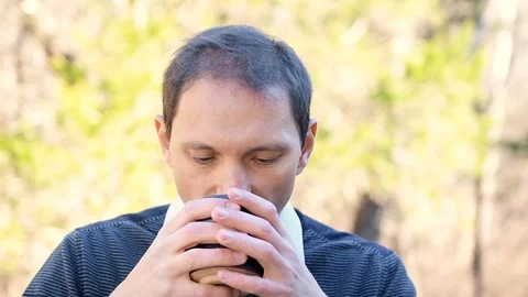 Happy man portrait closeup drinking tea outside in garden in slow motion Video stock 107937677
