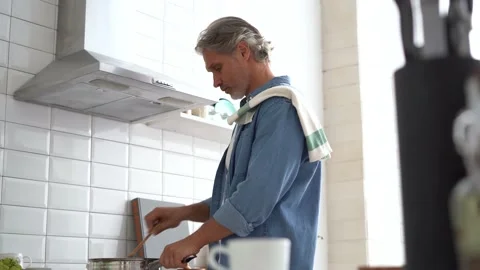 Happy man preparing romantic surprise, husband cooking healthy food in kitchen Stock Footage 142187936