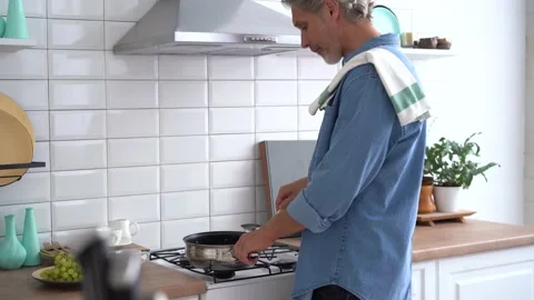 Happy man preparing romantic surprise, husband cooking healthy food in kitchen Stock Footage 142187972