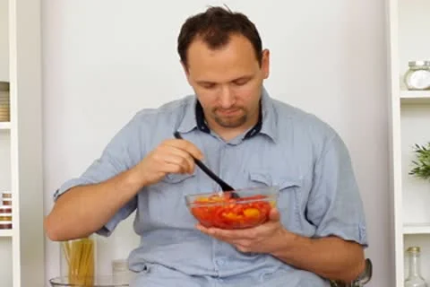 Happy man preparing a salad in the kitchen Stock Footage 8983531