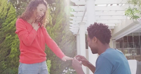 Happy man proposing on knees with ring to surprised woman Stock Footage 335452677