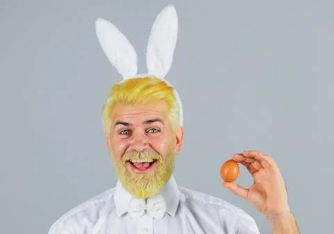 Happy man with rabbit ears with Easter egg. Male in bunny ears. Eggs hunt. Sp Stock Photos