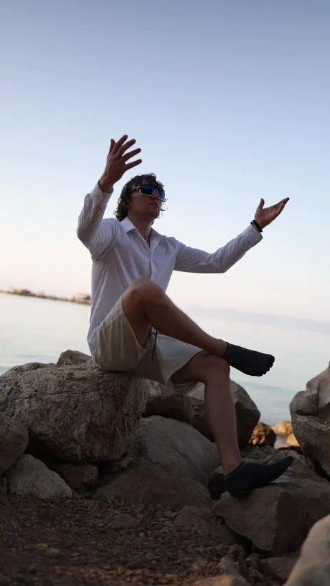 Happy man raises his hands with joy as he finally starts enjoying his seaside va Video stock 341621762