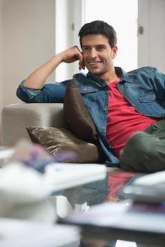 Happy man reclining on a couch Stock Photos