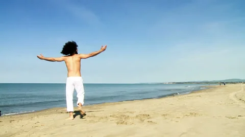 Happy man rotating arms and body on beach slow motion Stock Footage 37107404