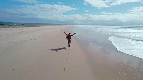 Happy man running on the beach Stock Footage 231473973