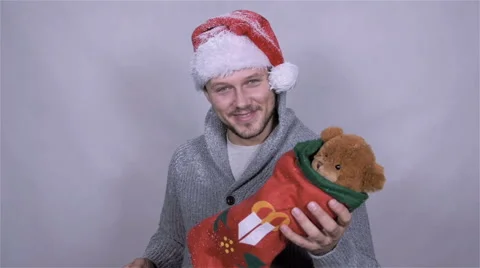 Happy man in Santa Claus hat with christmas gift. Slow motion. Stockbeeldmateriaal 44451671