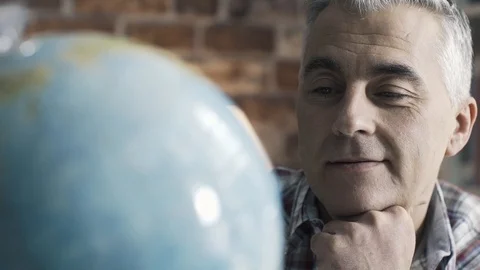 Happy man searching random places on a globe Stock Footage 103202802