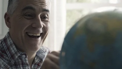 Happy man searching random places on a globe Stock Footage 103202841