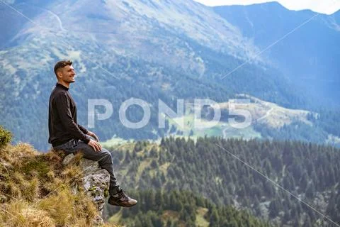 The happy man sitting on the cliff Stock Photos