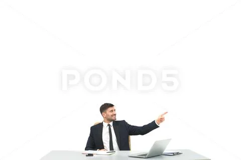 The happy man sitting at the desktop and gesturing on the white background Stock Photos