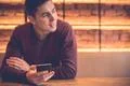 The happy man sitting with a phone at the restaurant table Photo