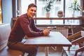 The happy man sitting with a tablet at the cafe table Photo