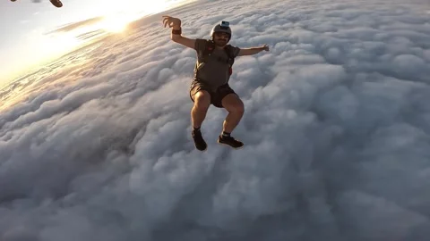 Happy man skydiving over the clouds at sunset Stock Footage 302391502