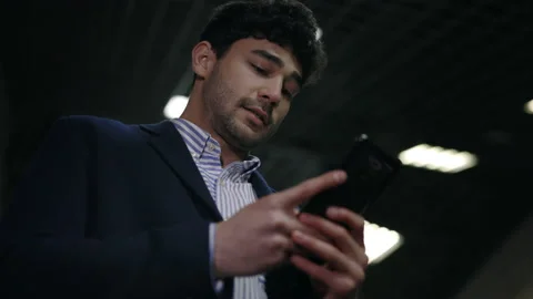 Happy man with smartphone moving down on escalator Stock Footage 154252477