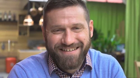 Happy man smiling to camera portrait, in pub, cafe, indoor, close steadicam shot Vidéo 73067208