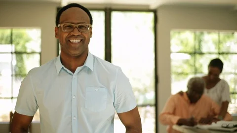 Happy man smiling while his family work on home finances. Vidéo 88368180