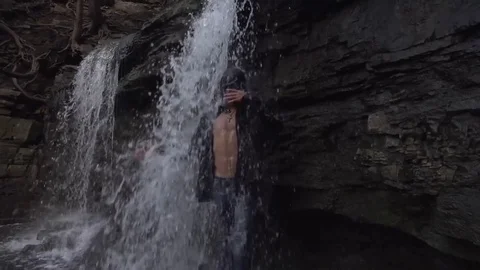 Happy Man Smiling while Under a Waterfall. Explore Adventure Stock Footage 79736568