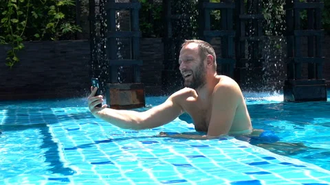 Happy man spending time in the pool and recording himself, slow motion  Stock Footage 88538007