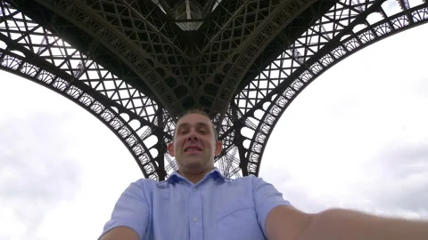 Happy man spinning under the Eiffel Tower in Paris in 4k slow motion Video stock 88642934