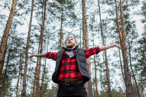 Happy man in spring or summer forest park raising arms with happiness Stock Photos