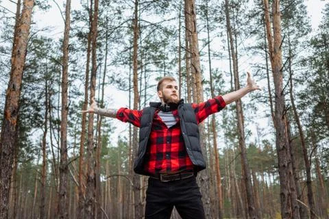 Happy man in spring or summer forest park raising arms with happiness Stock Photos