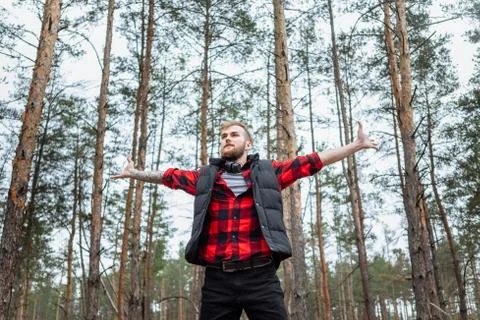 Happy man in spring or summer forest park raising arms with happiness Stock Photos