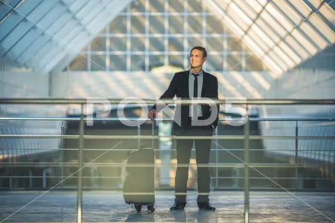 The happy man stand with a suitcase in the business center Stock Photos